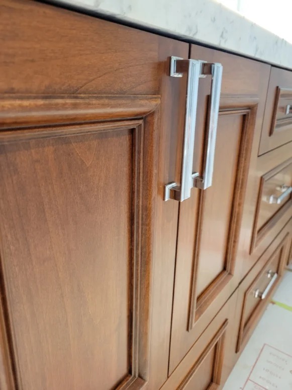 Finished walnut-tone cabinet hardware detail
